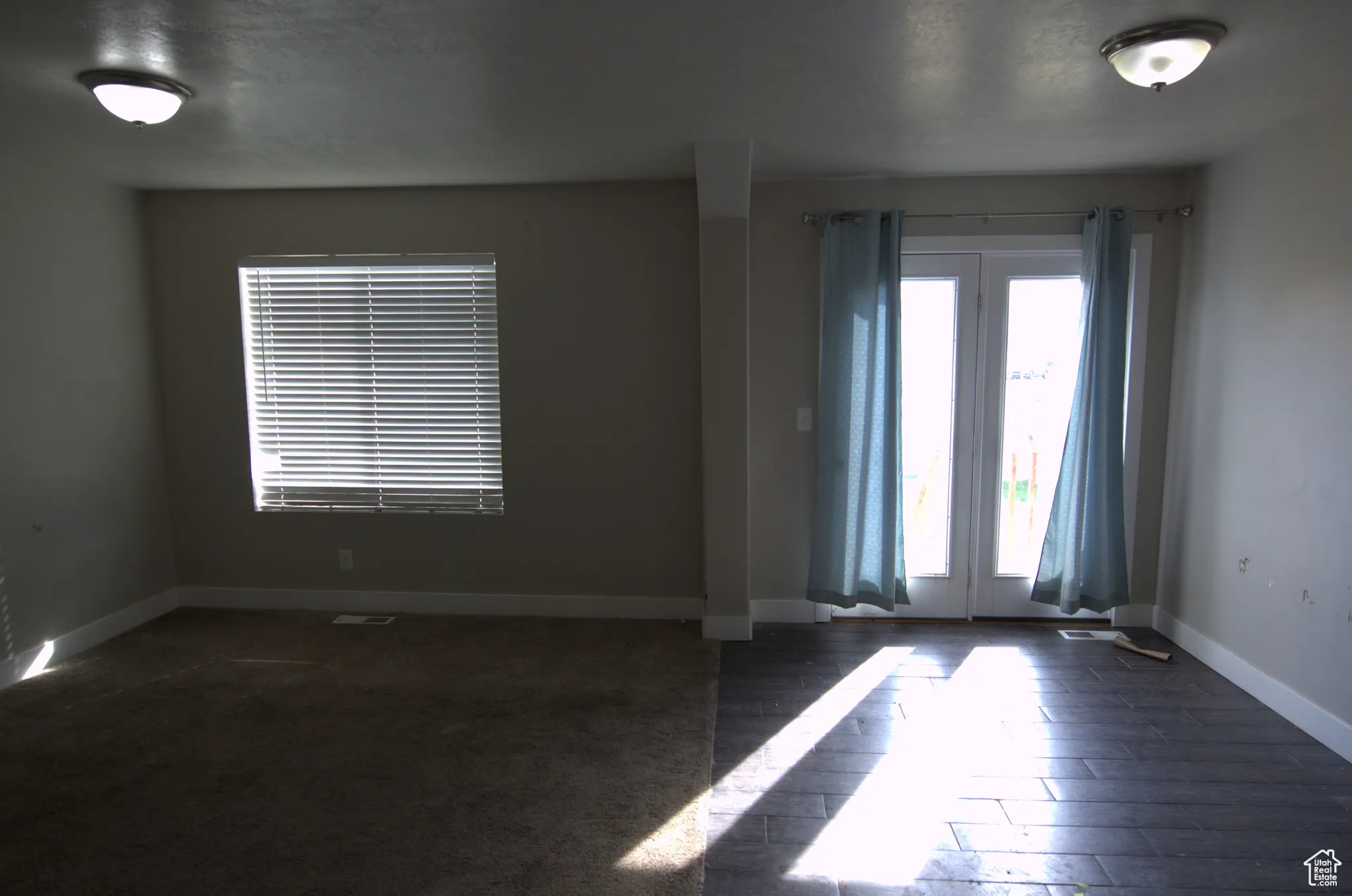Empty room featuring baseboards and dark wood-style flooring