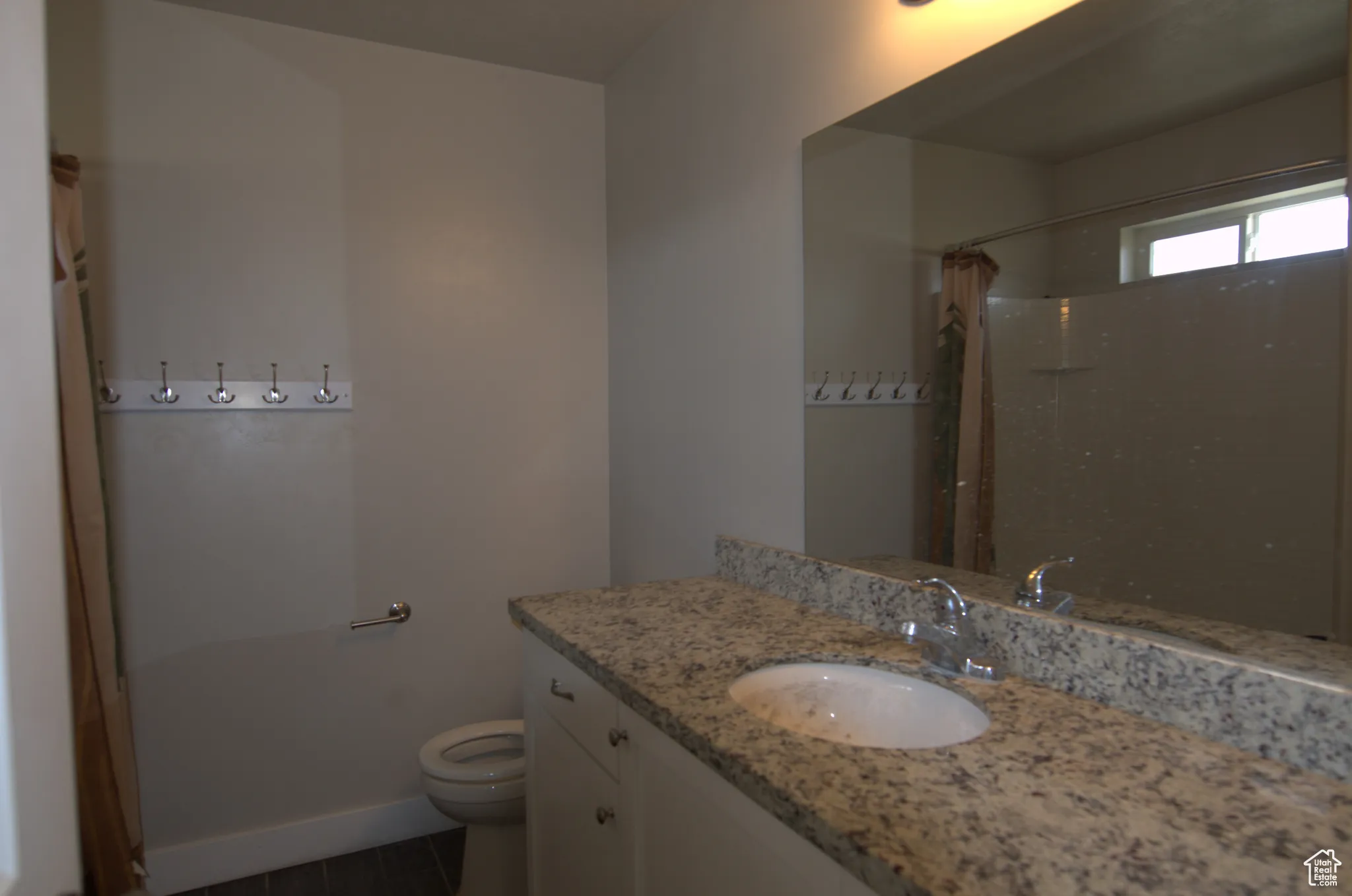 Bathroom featuring vanity, a shower with curtain, and dark tile patterned flooring
