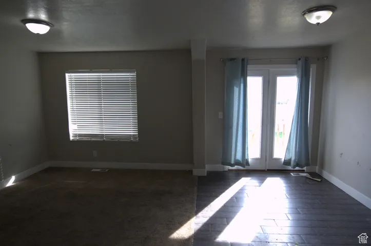 Empty room featuring baseboards and dark wood-style flooring