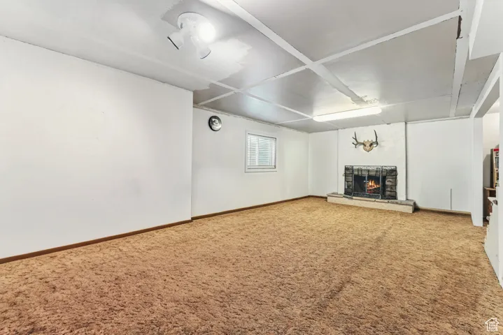 Unfurnished living room featuring a fireplace and carpet flooring