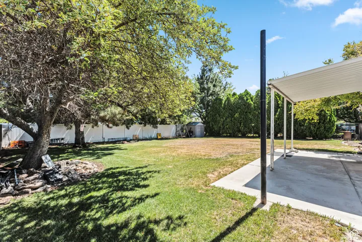 Fenced backyard featuring a storage unit