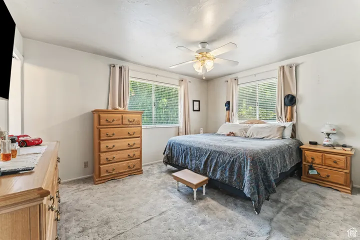 Bedroom with light colored carpet and ceiling fan