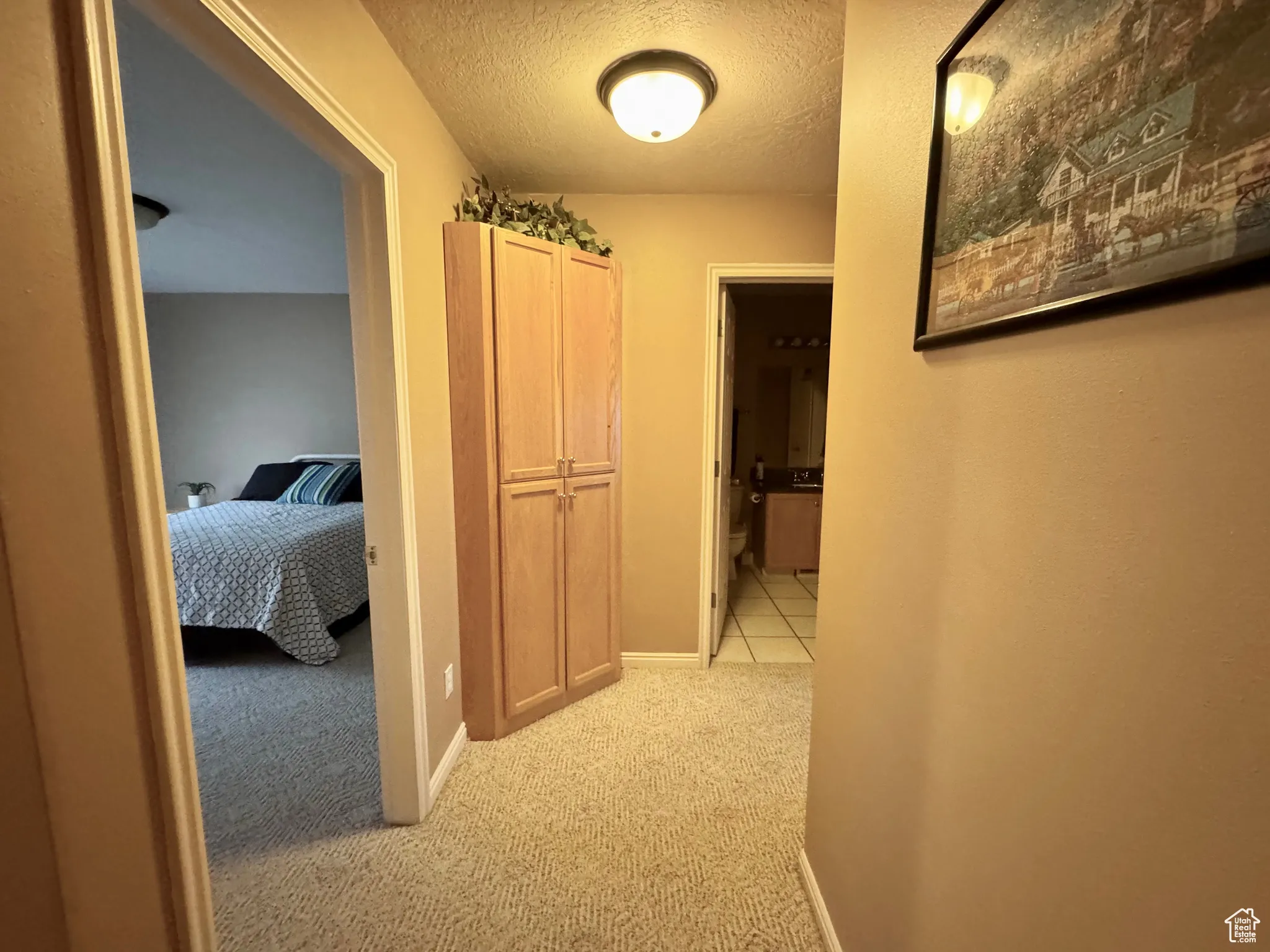 Hall with a textured ceiling and light carpet