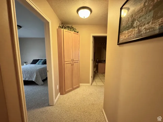 Hall with a textured ceiling and light carpet