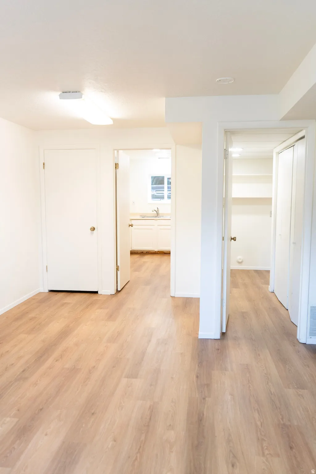 Below grade area with light wood-type flooring and baseboards