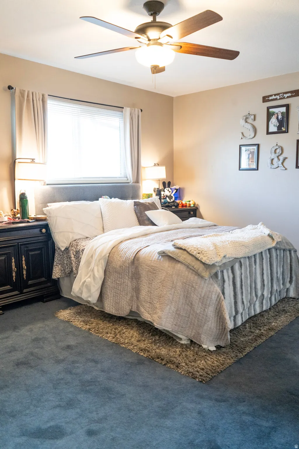 Bedroom with a ceiling fan and dark colored carpet