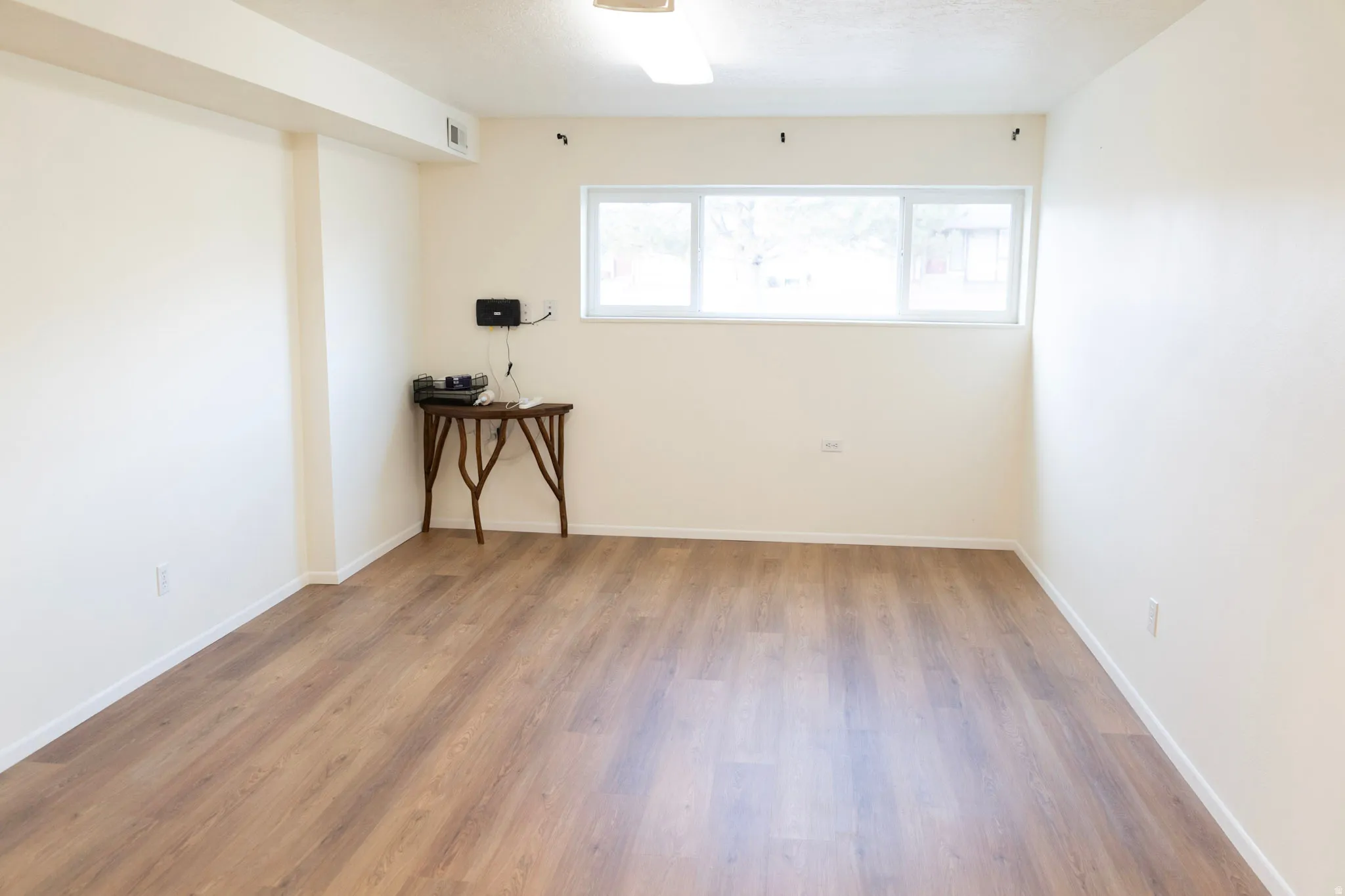 Unfurnished room with light wood-style flooring and baseboards