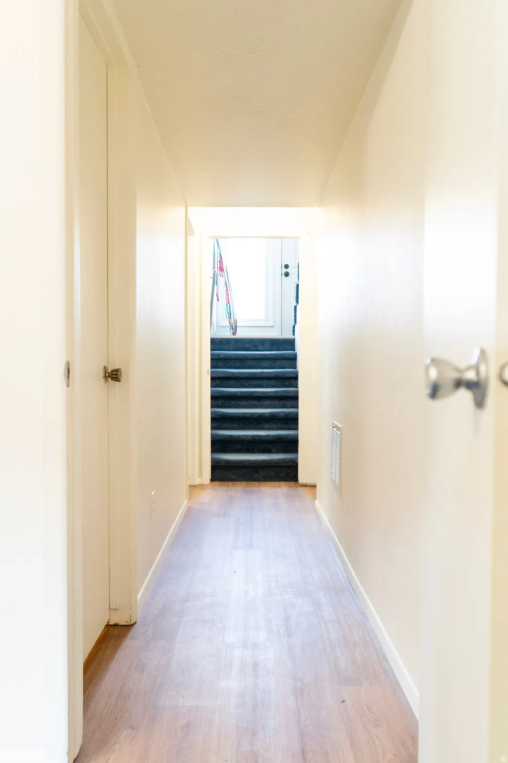 Hallway with stairway and light wood-type flooring