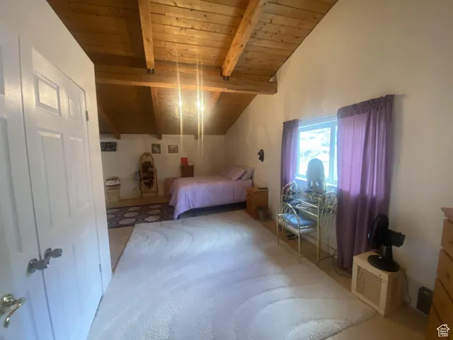 Carpeted bedroom featuring wooden ceiling