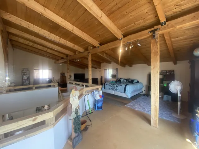 Bedroom featuring wooden ceiling and concrete flooring