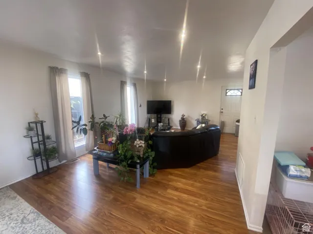 Living area with dark wood-style flooring and baseboards
