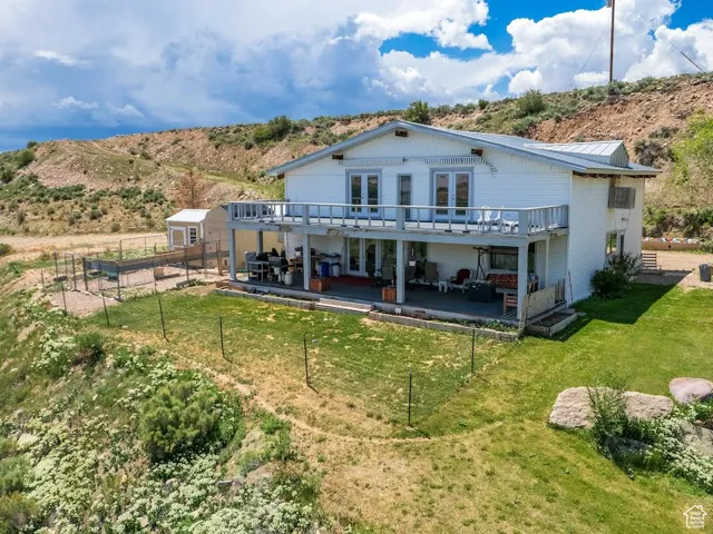 Rear view of house featuring french doors, a metal roof, a patio, and a storage shed