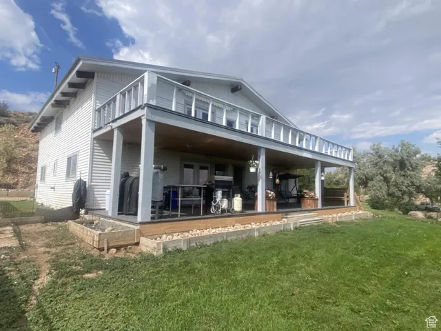 Back of property with a yard and covered porch