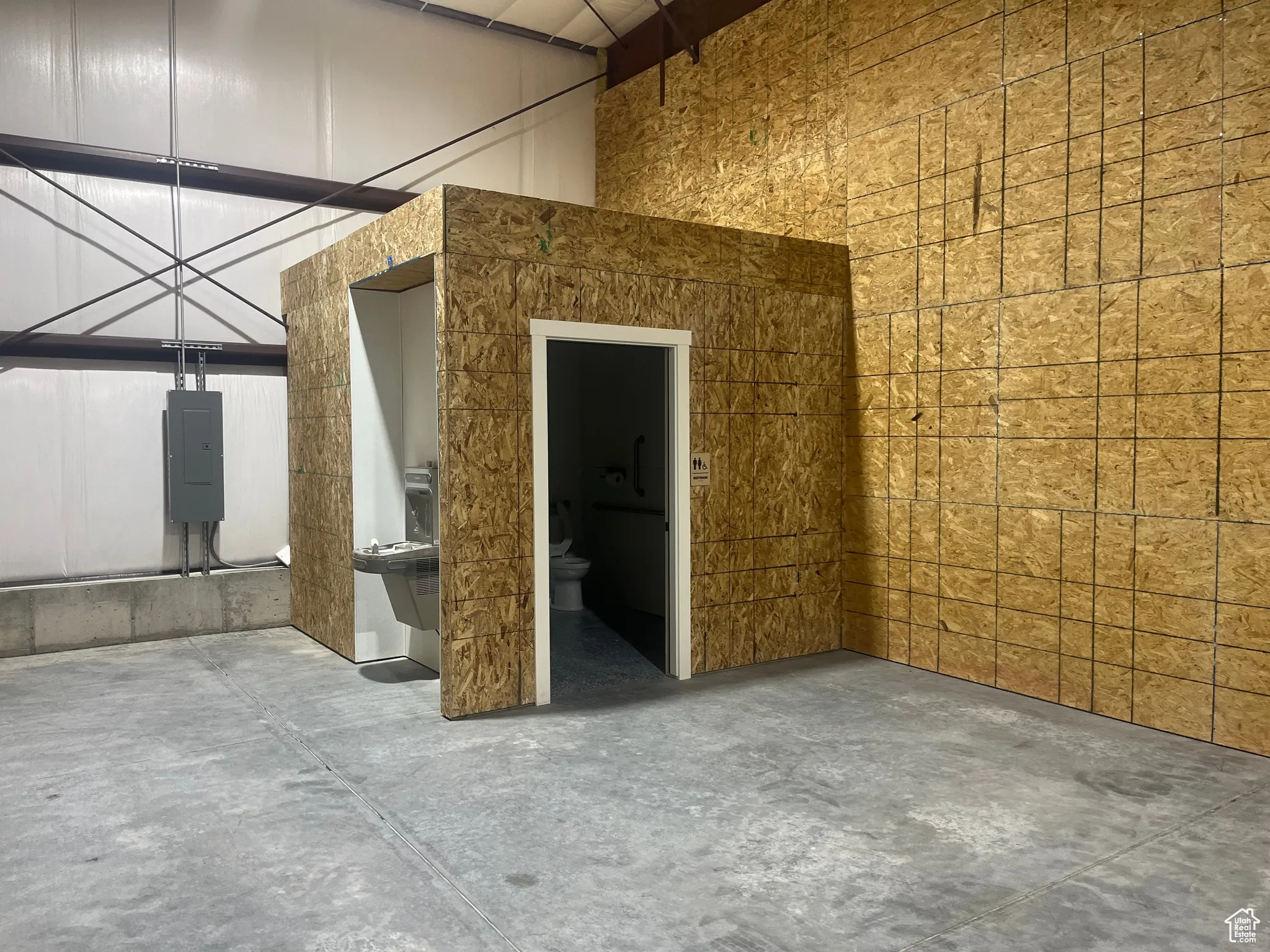 Empty room featuring concrete flooring and electric panel