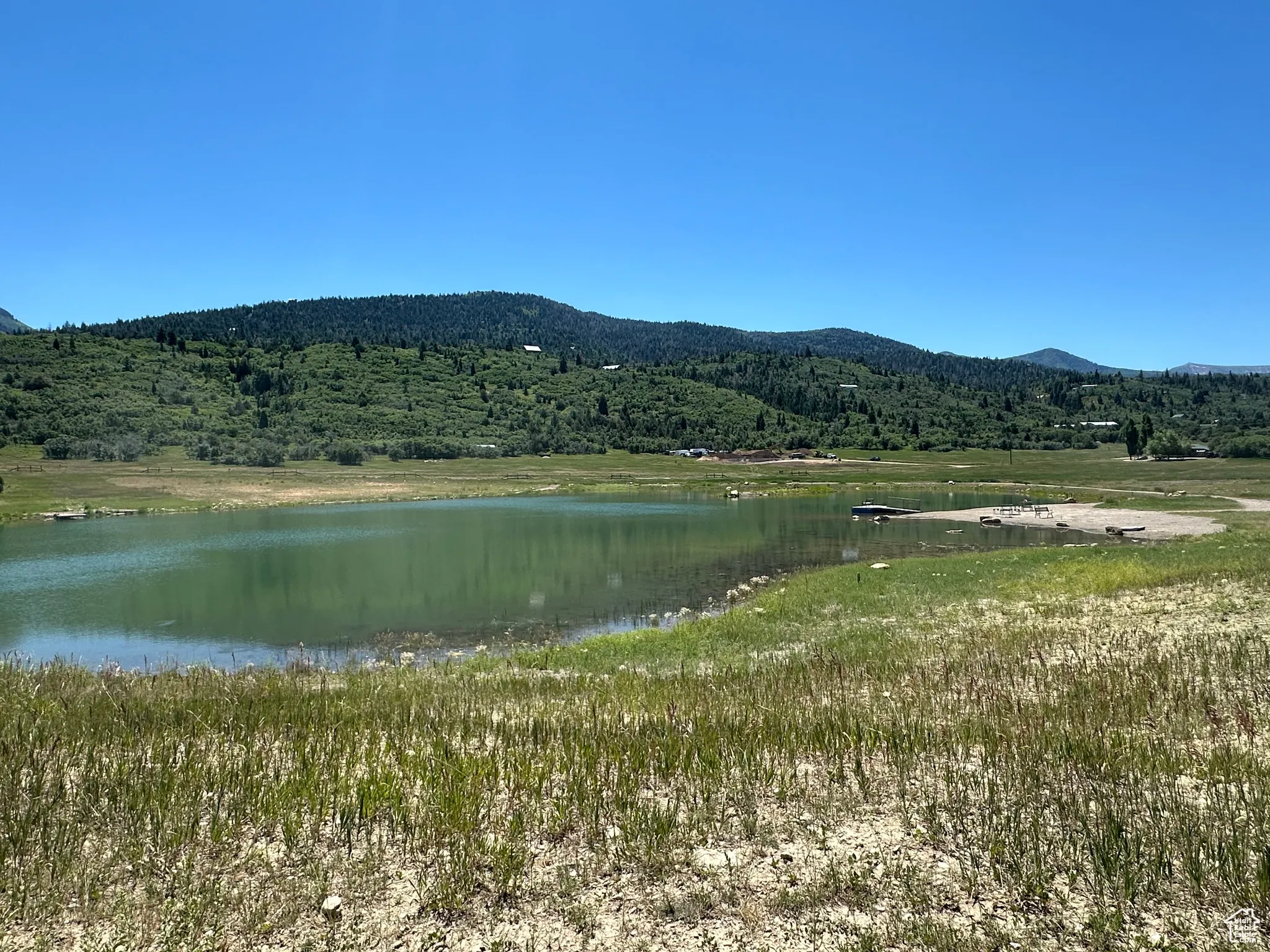 View of mountain backdrop featuring a large body of water and a heavily wooded area