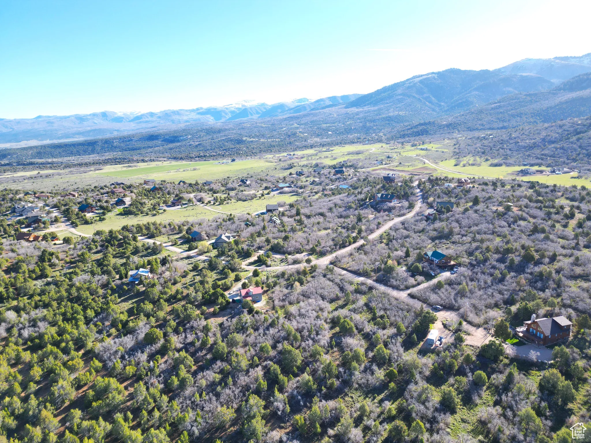 Aerial view of property and surrounding area featuring a mountainous background
