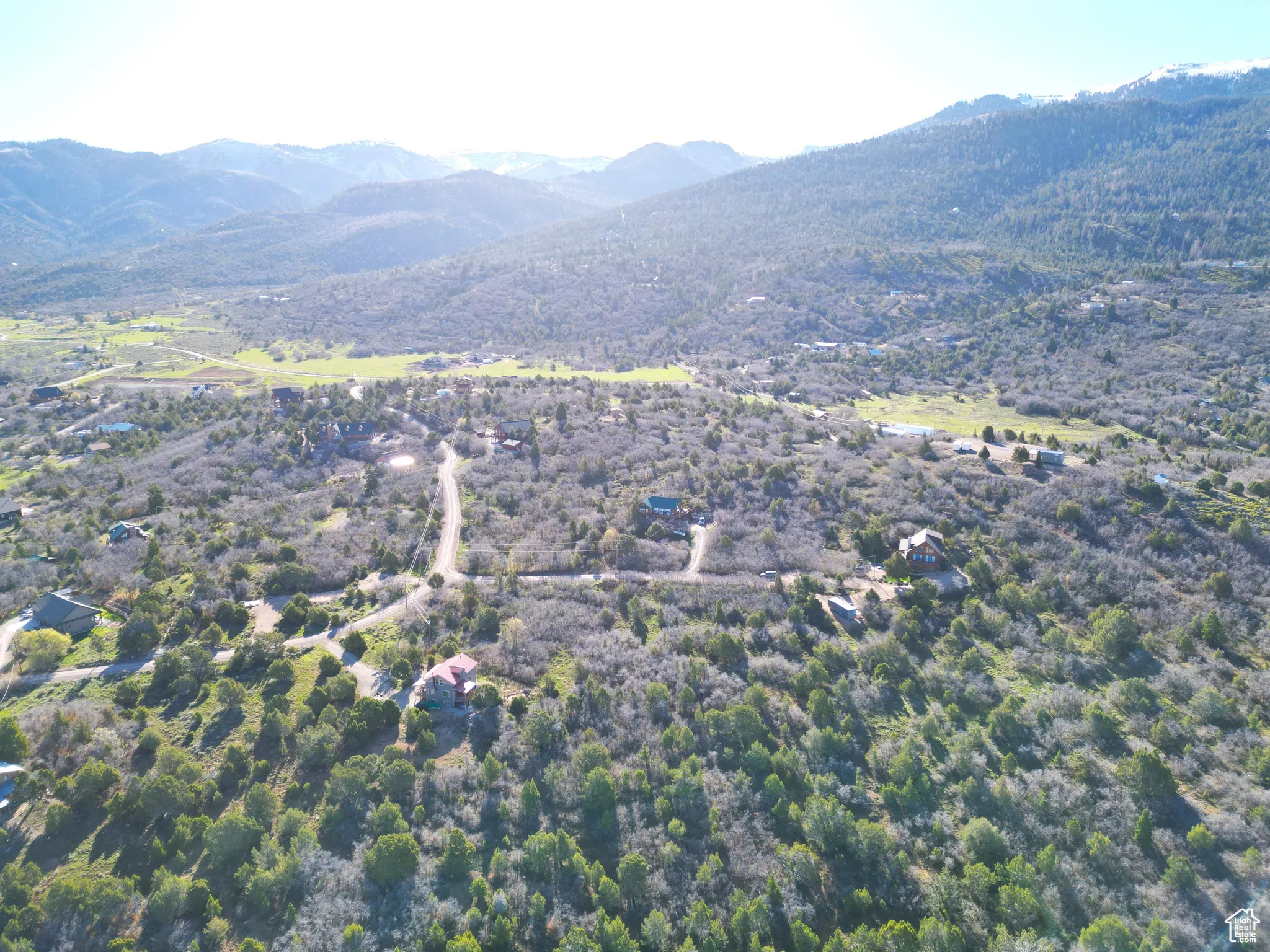 Aerial view of property and surrounding area featuring a mountainous background