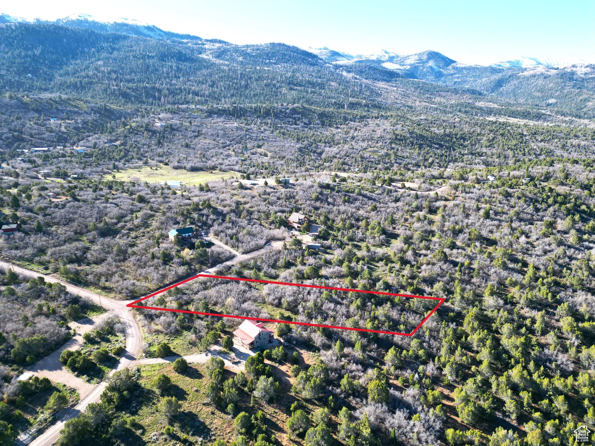 Aerial view of property and surrounding area featuring property parcel outlined and a mountainous background
