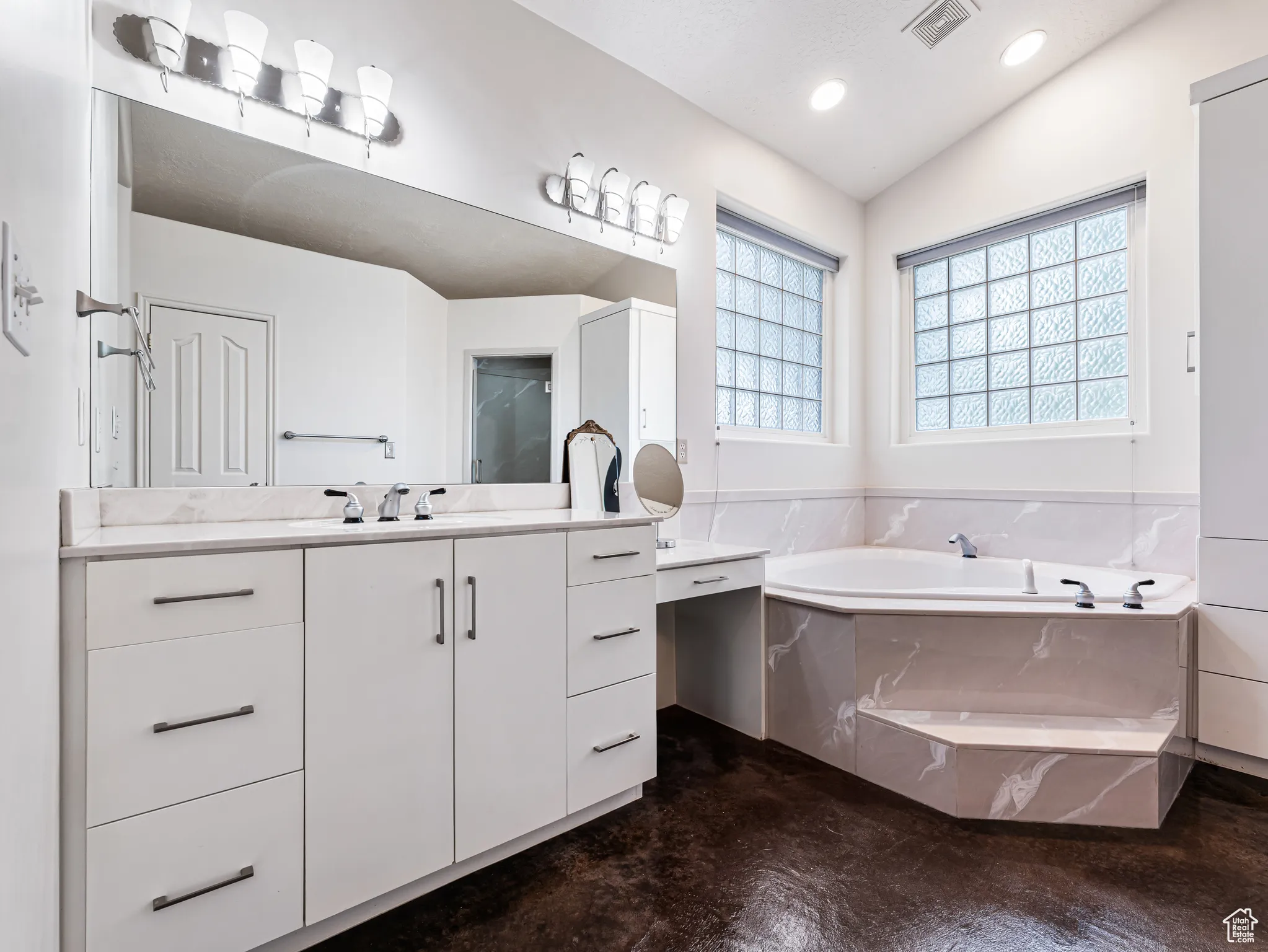 Ensuite Bathroom featuring vanity, jetted tub, recessed lighting, and lofted ceiling..color is off from lighting.. new photo coming soon.