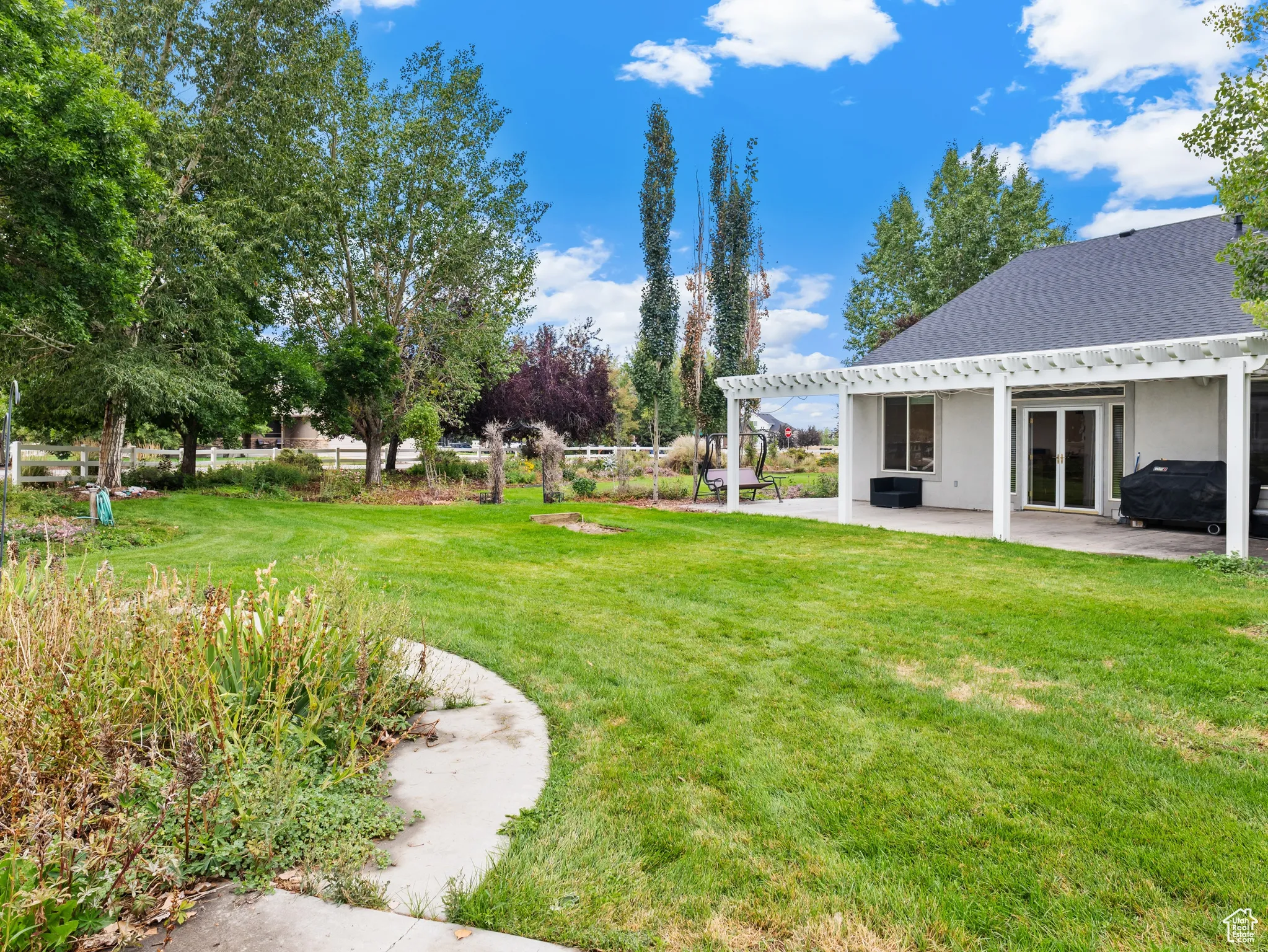 View of grassy yard with a patio area and a pergola
