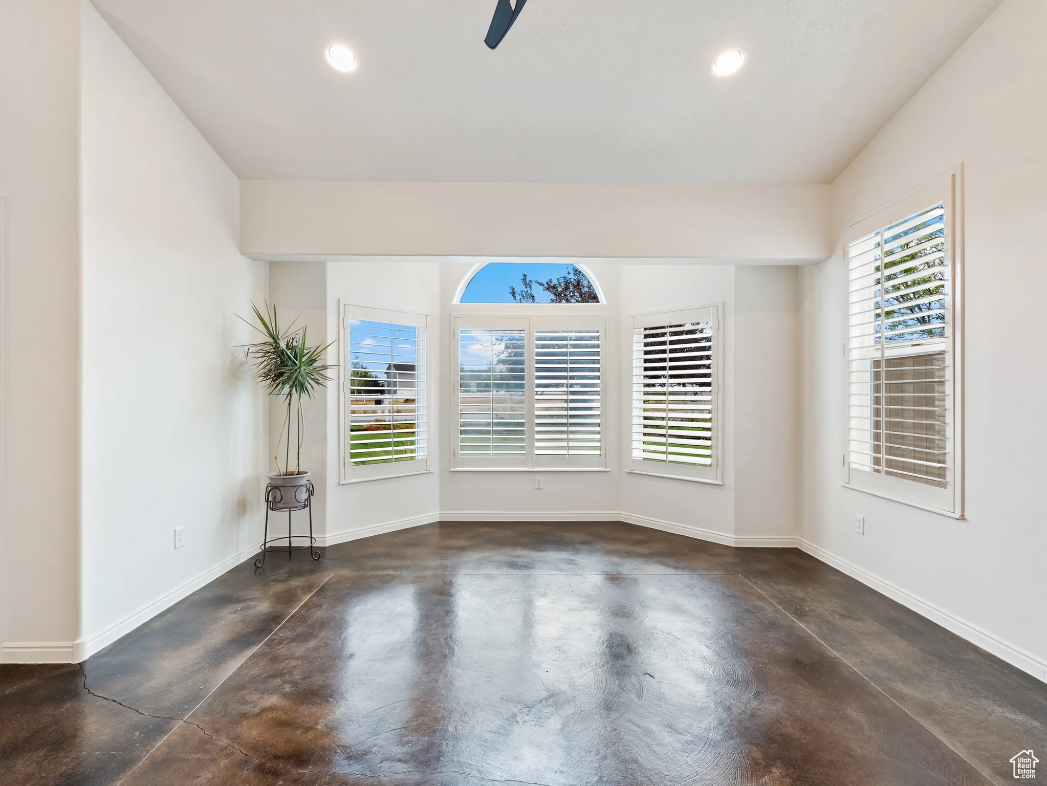 Empty room with concrete flooring, recessed lighting, and a ceiling fan