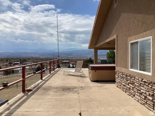 View of patio featuring a mountain view and a hot tub