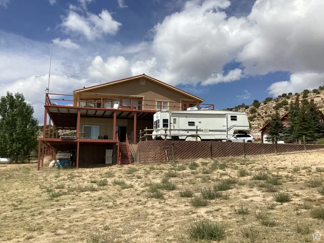 Back of house with a deck and stairs