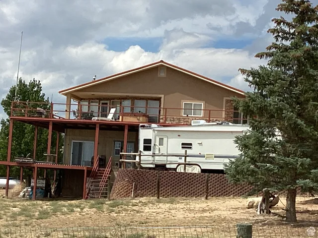 Back of property featuring a balcony, stairway, and a deck
