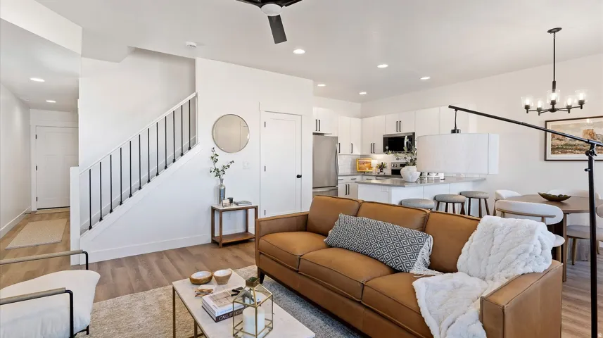 Living area featuring light wood-type flooring, a chandelier, and ceiling fan