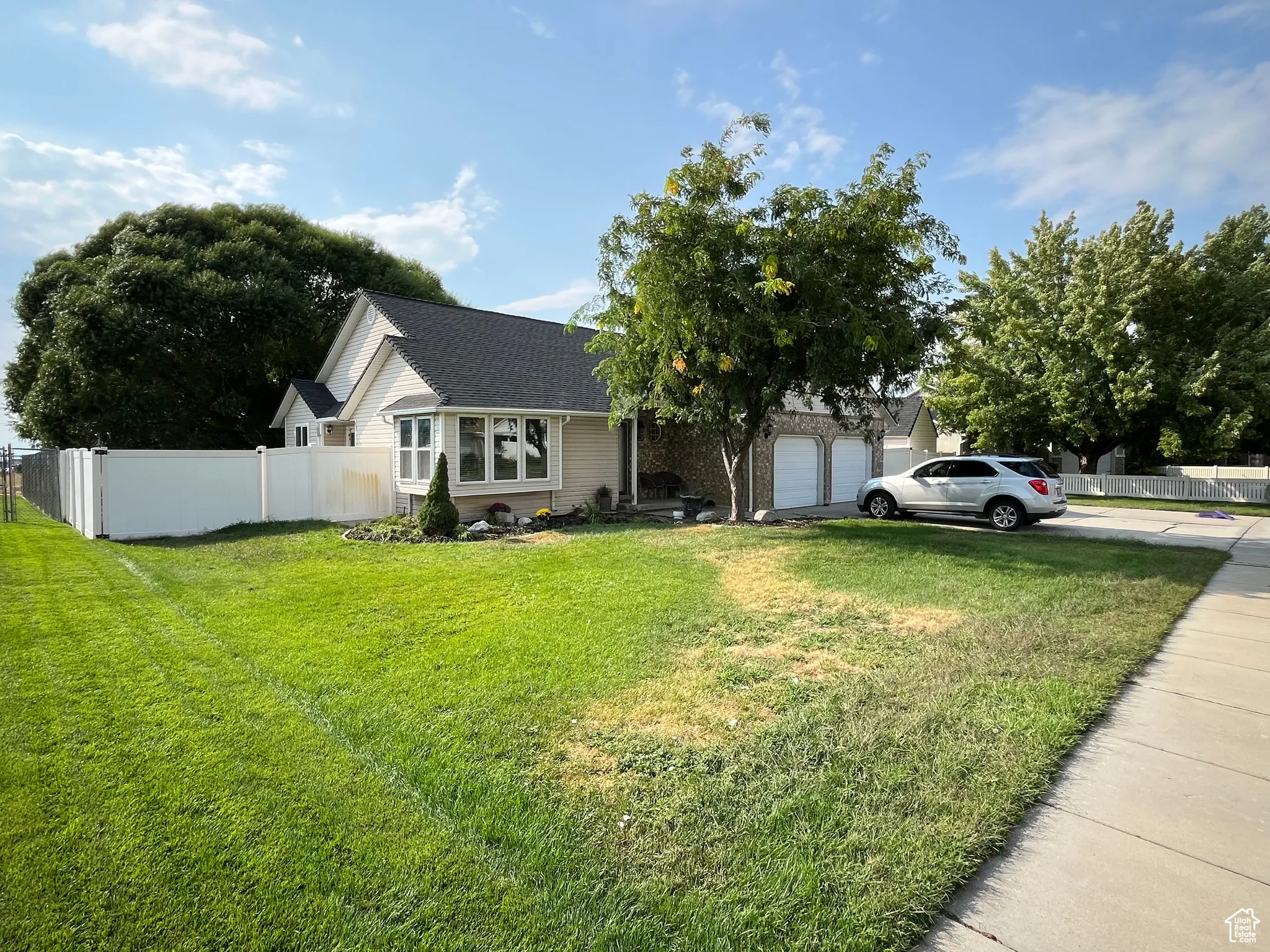 View of front of house featuring concrete driveway, a shingled roof, and a garage