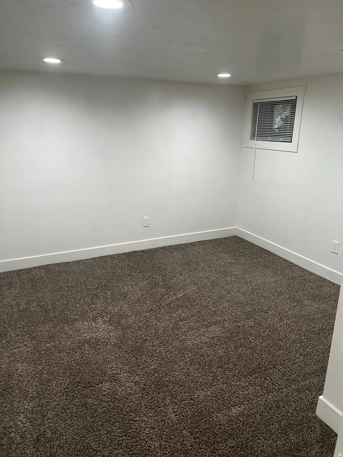 Spare room with dark colored carpet and recessed lighting