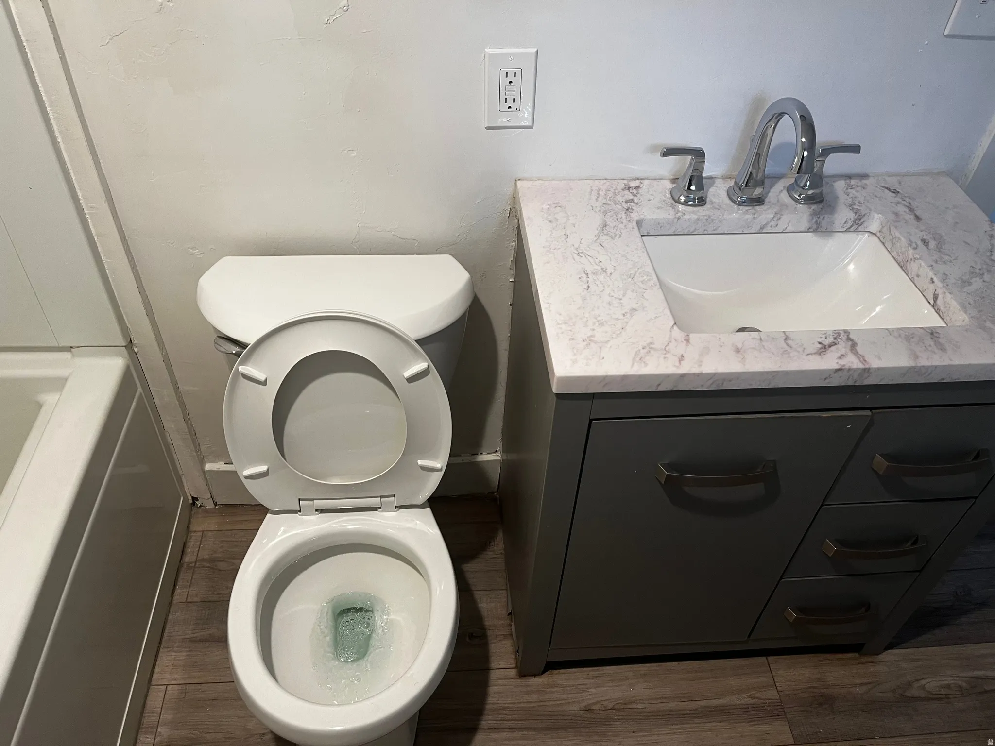 Bathroom featuring vanity, light wood-type flooring, and a bath