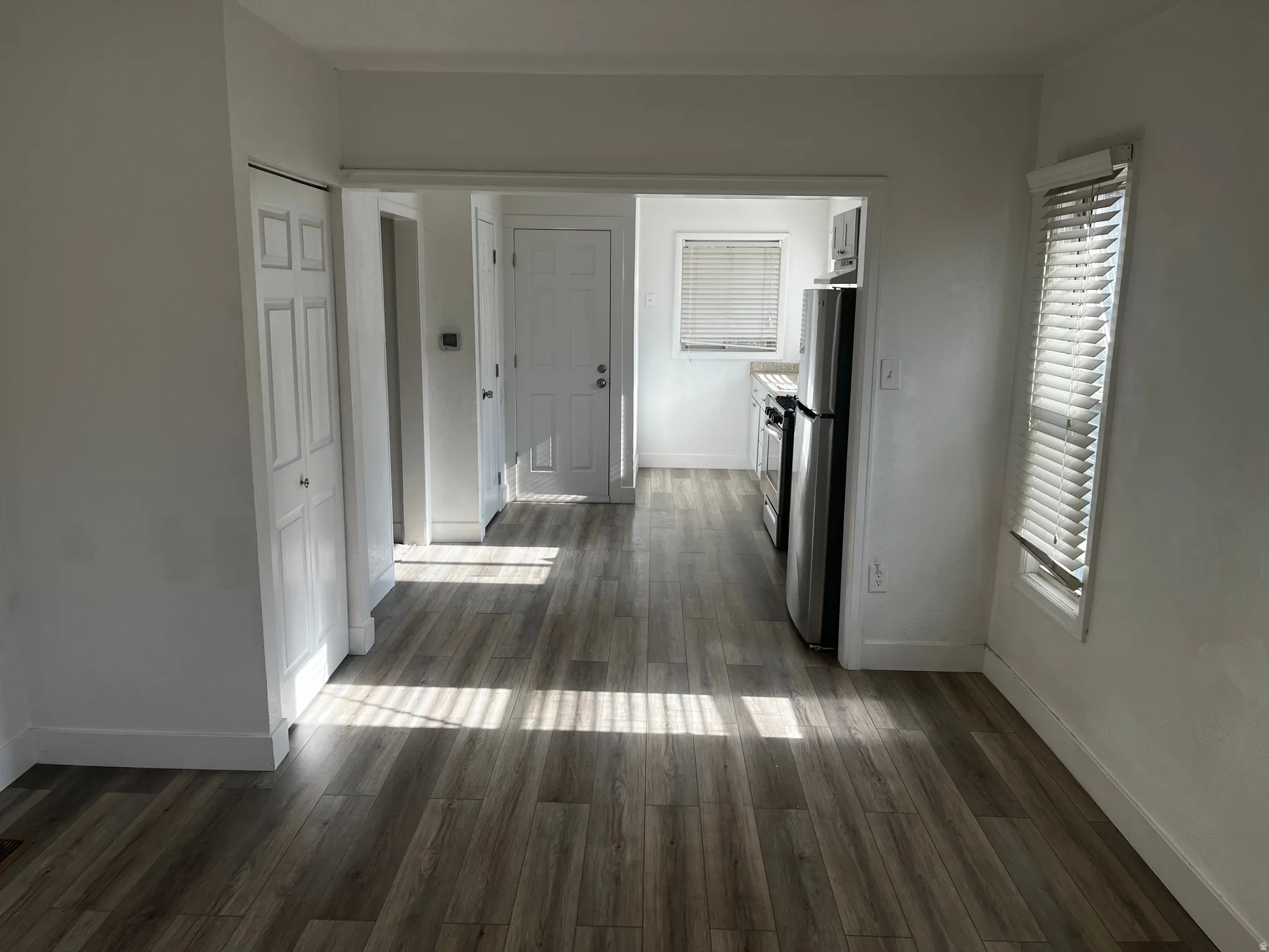 Corridor featuring baseboards and dark wood-type flooring