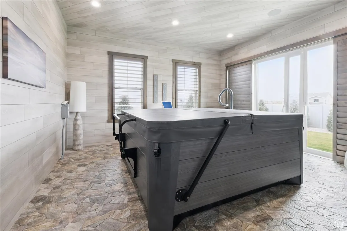 Kitchen with plenty of natural light, stone flooring, recessed lighting, light countertops, and wood ceiling