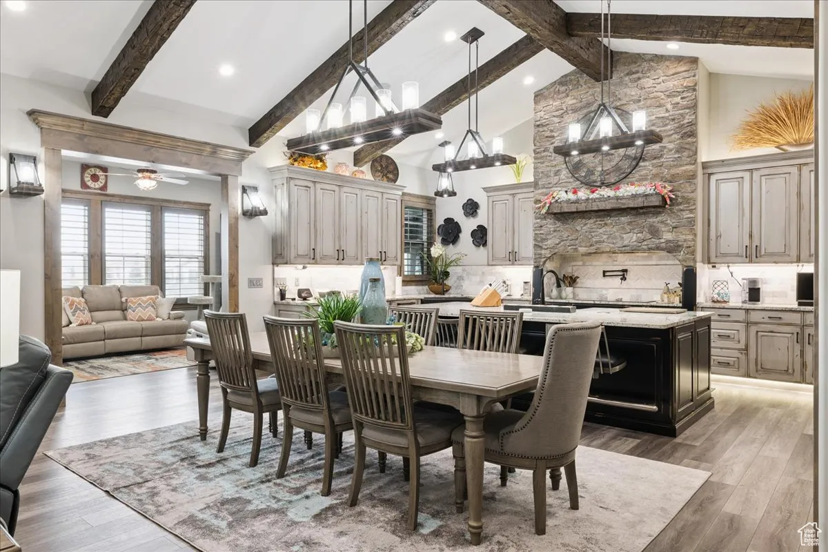 Dining space with beam ceiling, dark wood-type flooring, high vaulted ceiling, recessed lighting, and a ceiling fan