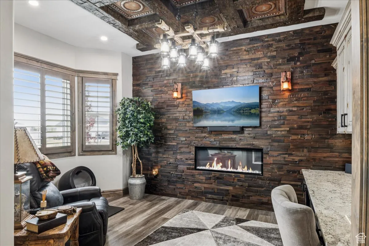 Living area featuring wood finished floors and a glass covered fireplace