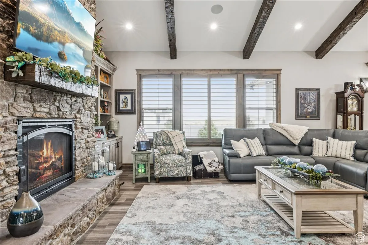 Living area with wood finished floors, a fireplace, recessed lighting, and beamed ceiling
