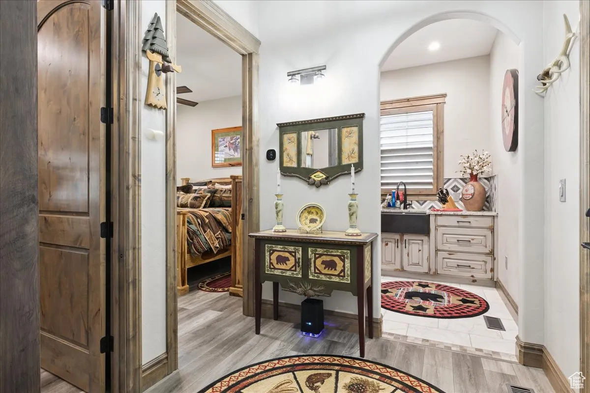 Hallway featuring light wood finished floors and arched walkways