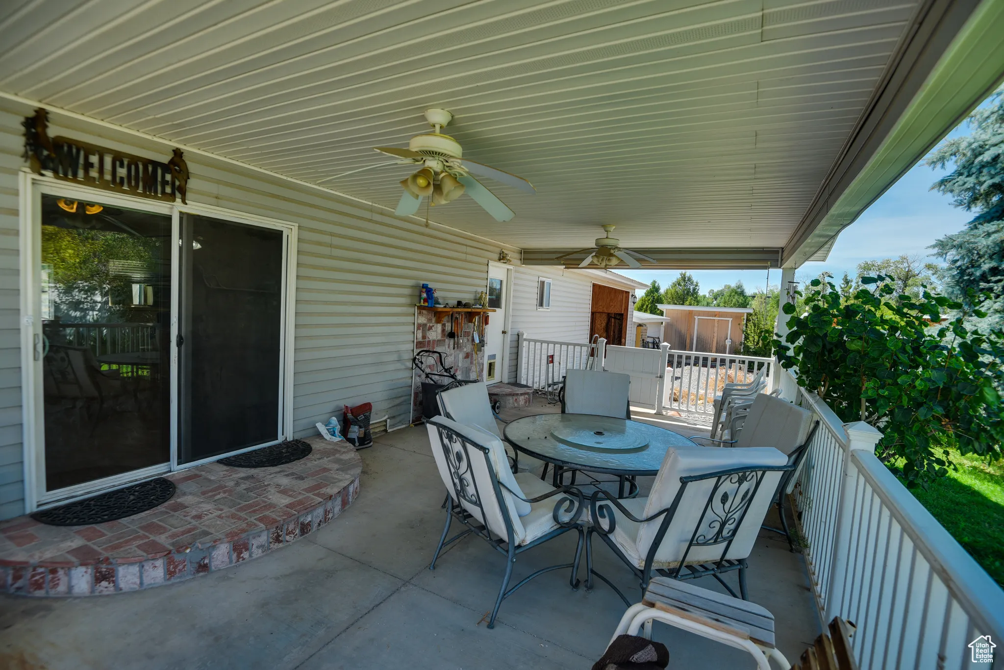 View of patio with outdoor dining area and ceiling fan