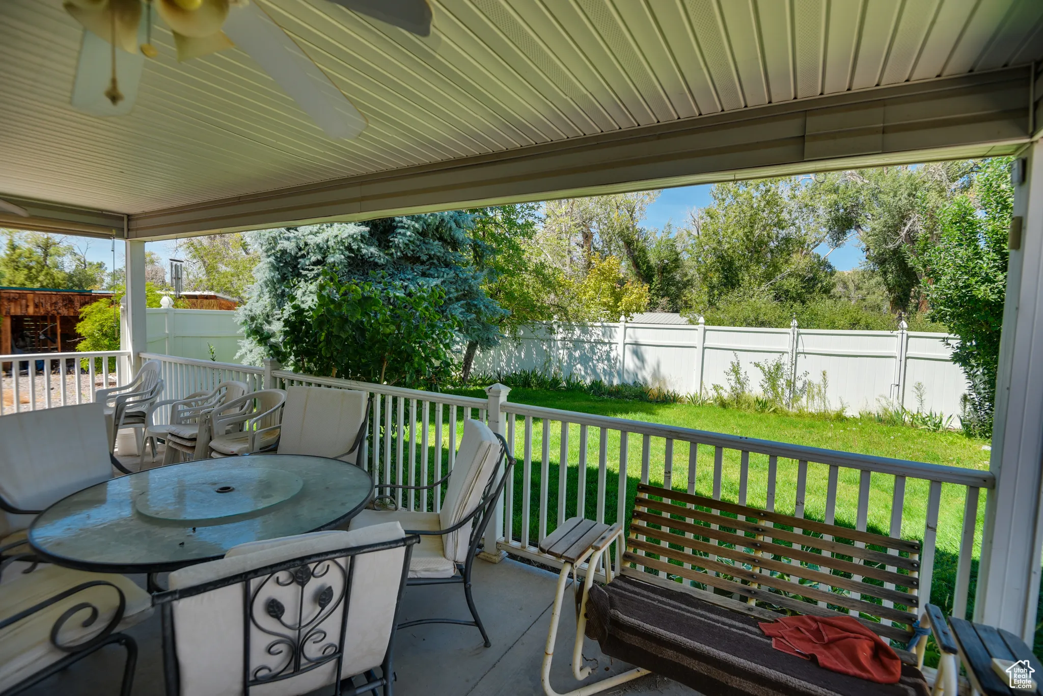 Fenced backyard with ceiling fan and outdoor dining area