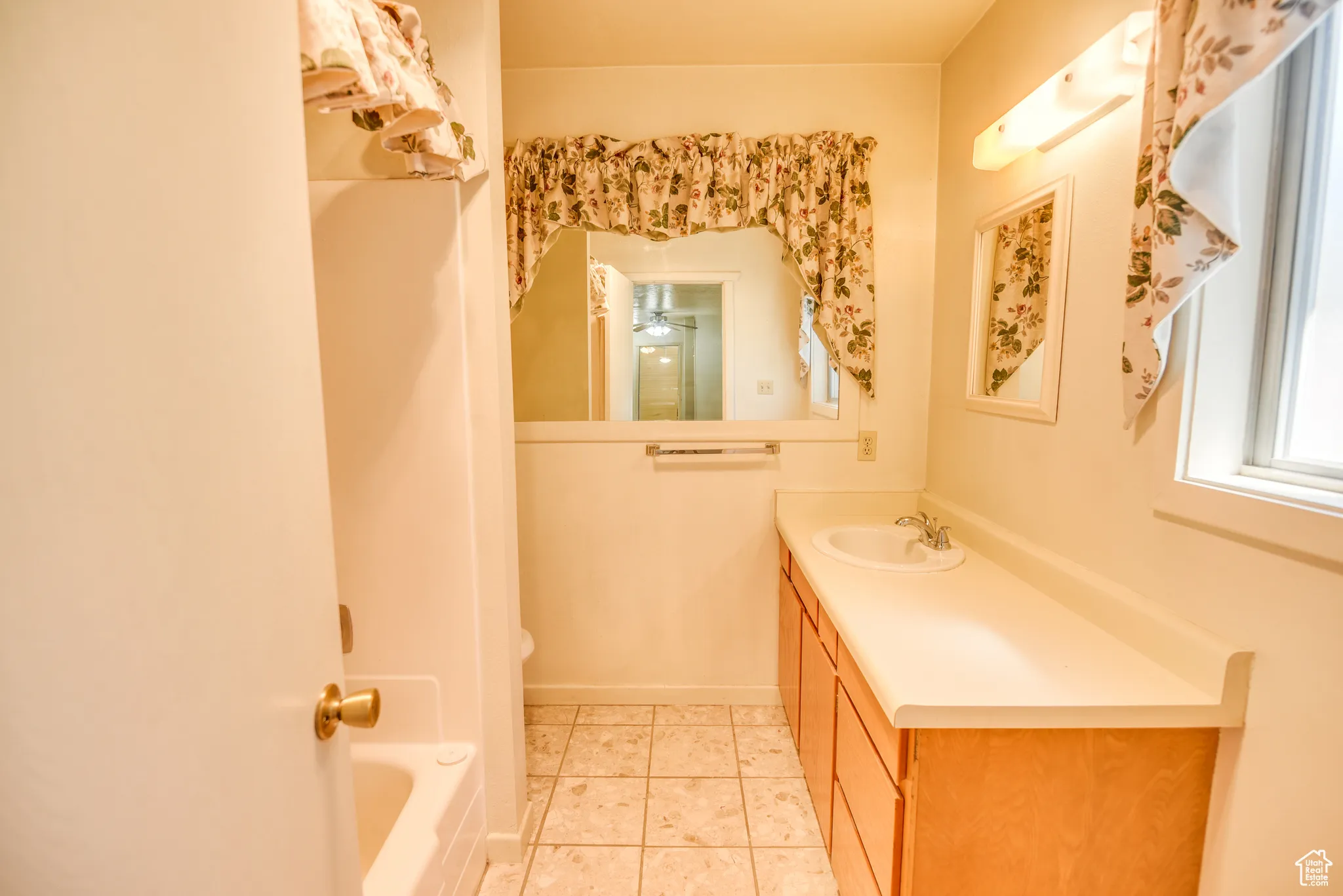 Bathroom featuring light tile patterned floors, vanity, and bathing tub / shower combination