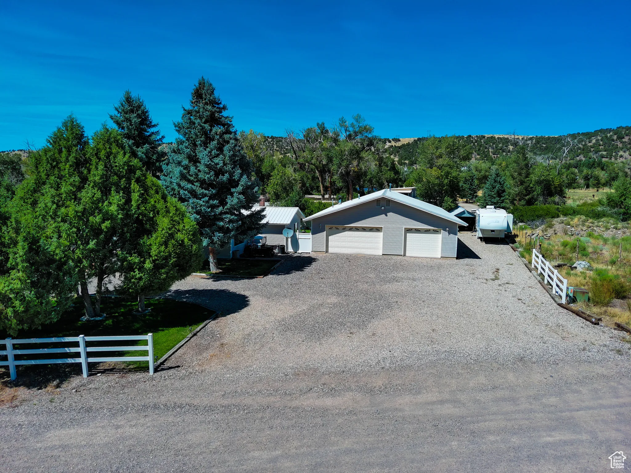 View of front of house with an outbuilding and gravel driveway