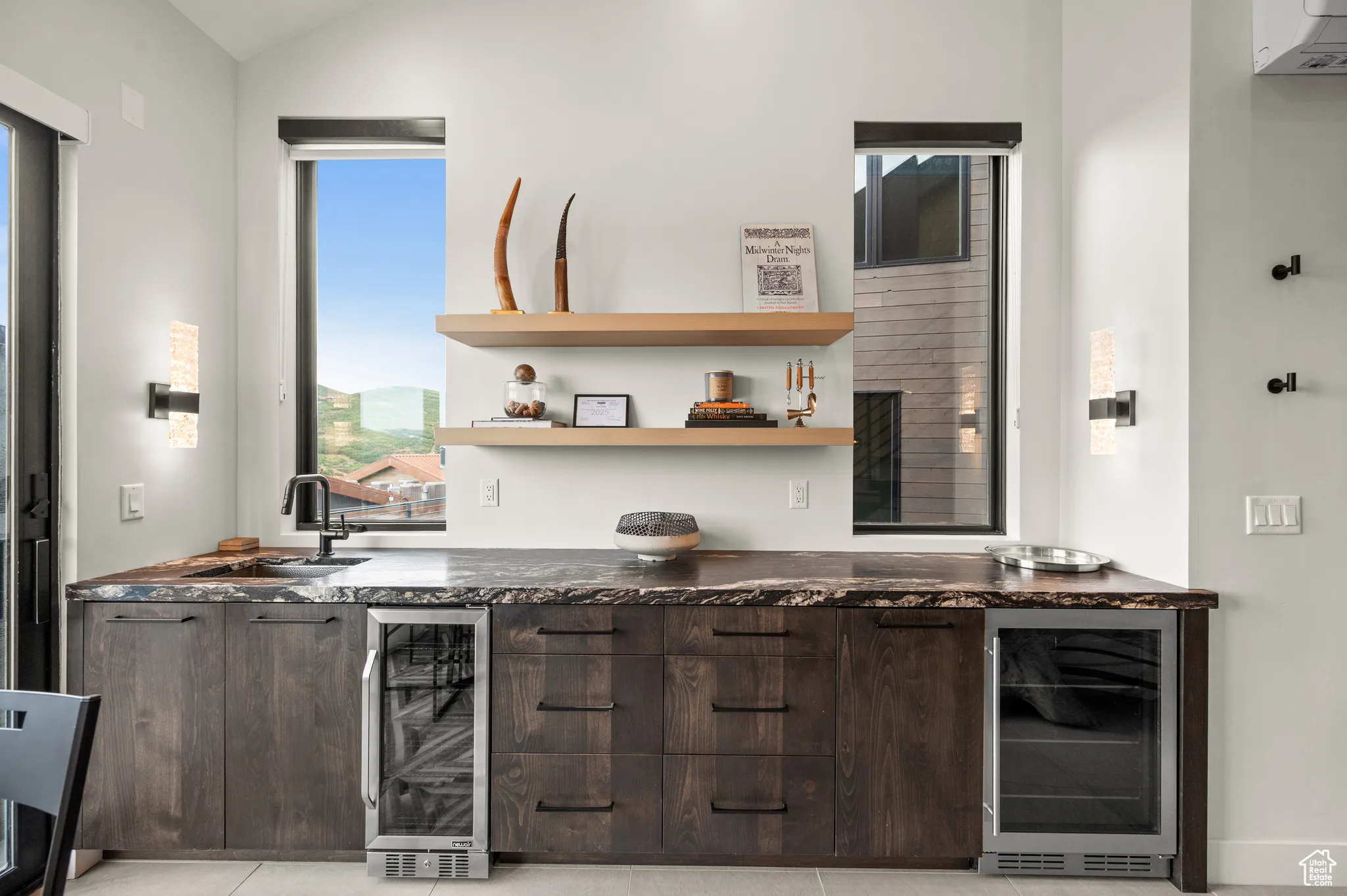 The wet bar features stylish leathered granite and space to store cold beverages.
