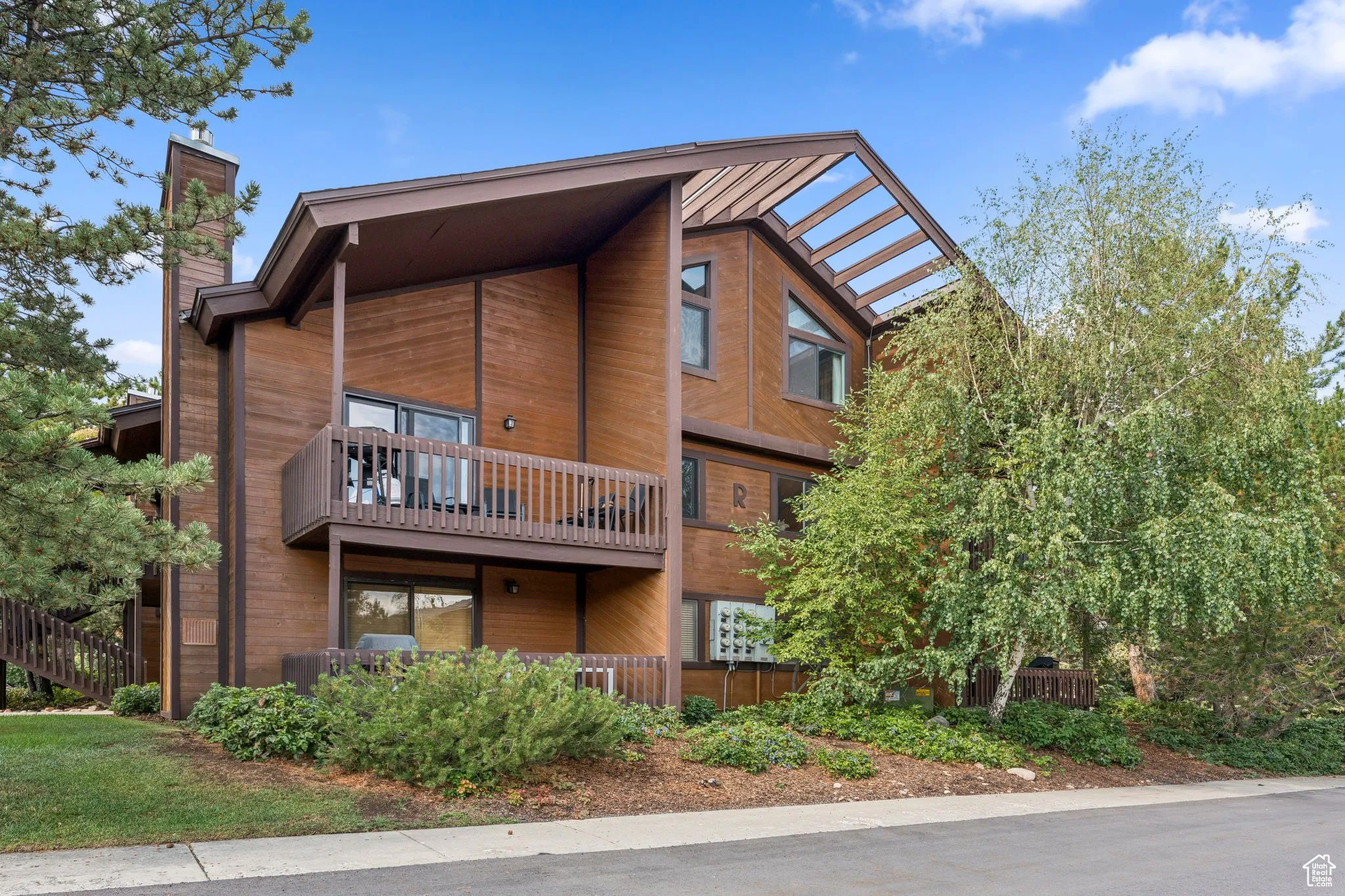 Rear view of property with a chimney and a balcony