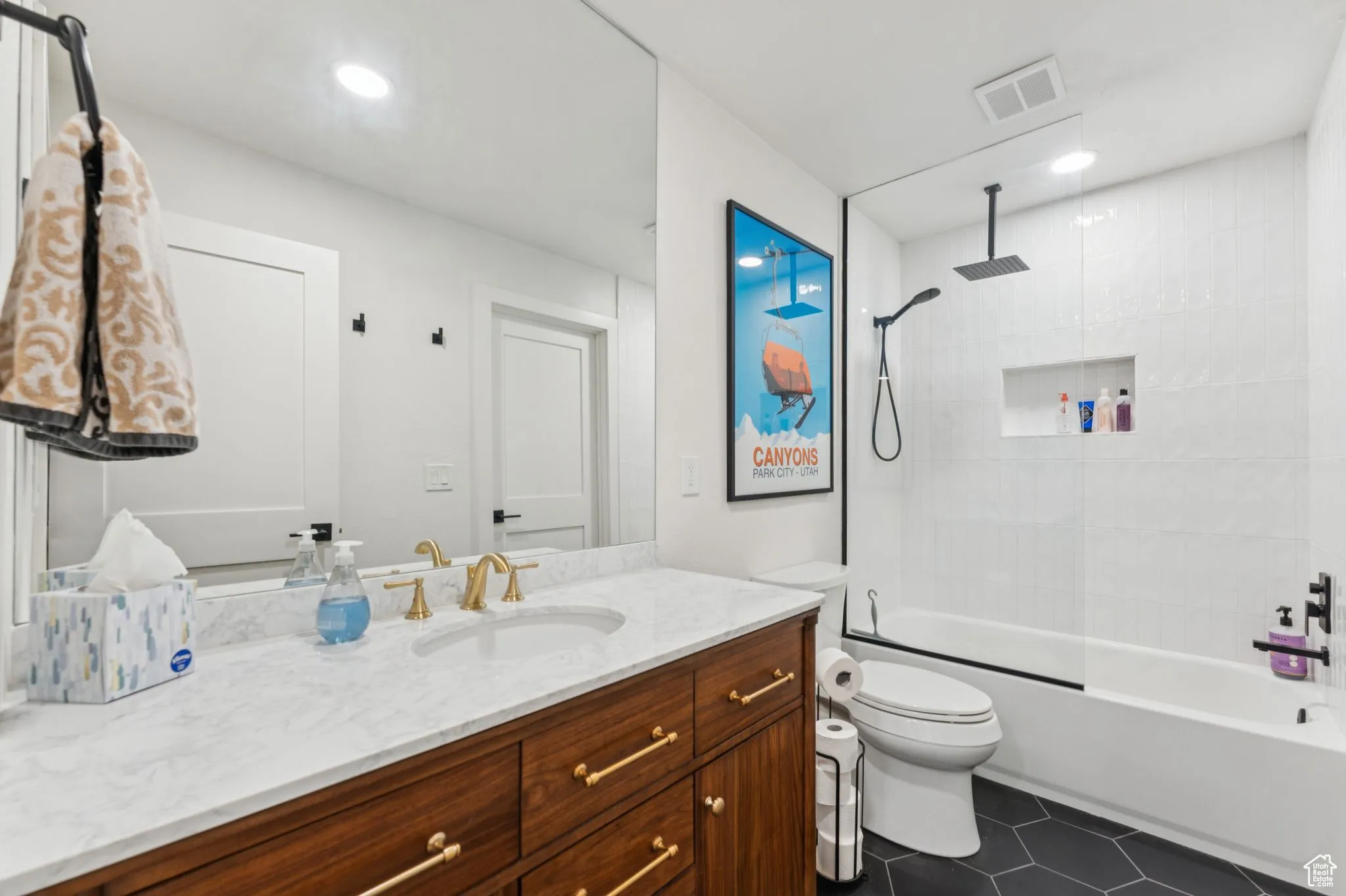 Full bathroom with a combined bath / shower with rainfall shower, vanity, and dark tile patterned floors