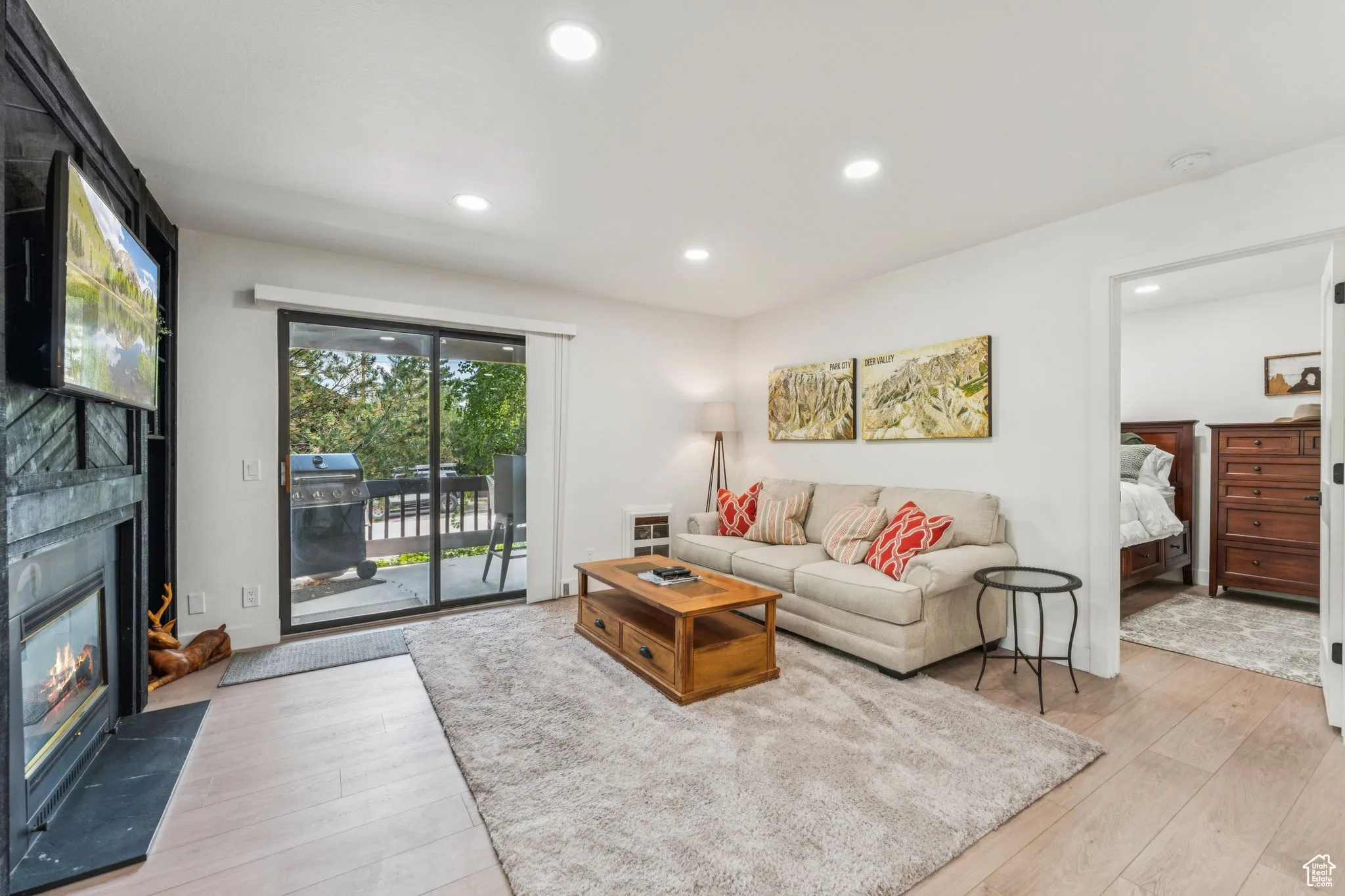 Living room with recessed lighting, light wood-style floors, and a fireplace