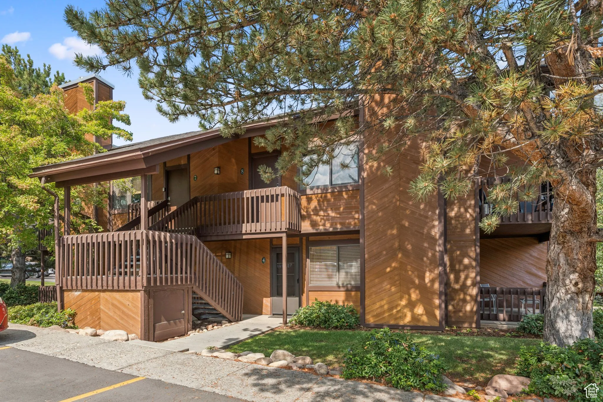 View of front of house featuring stairway, a balcony, and a chimney