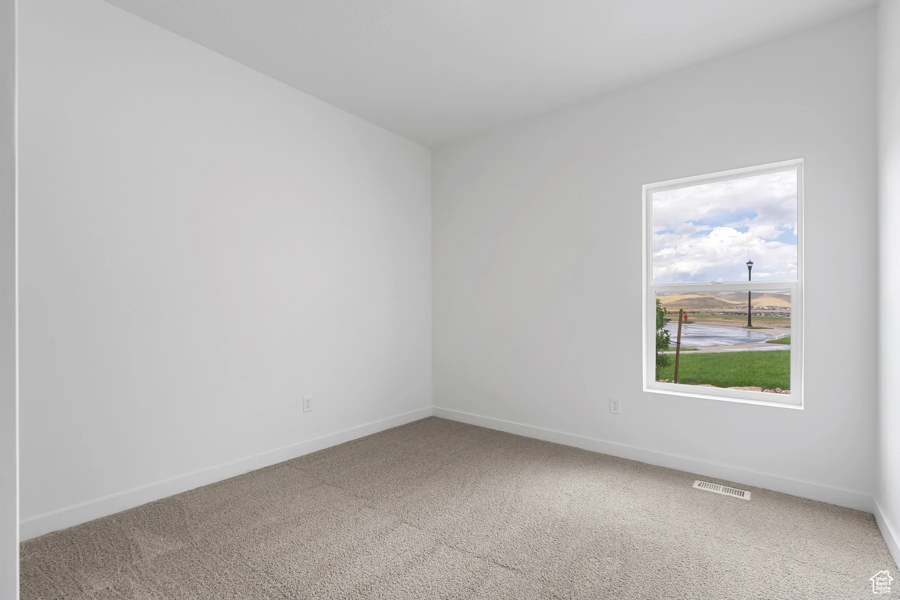 Spare room featuring light carpet and baseboards