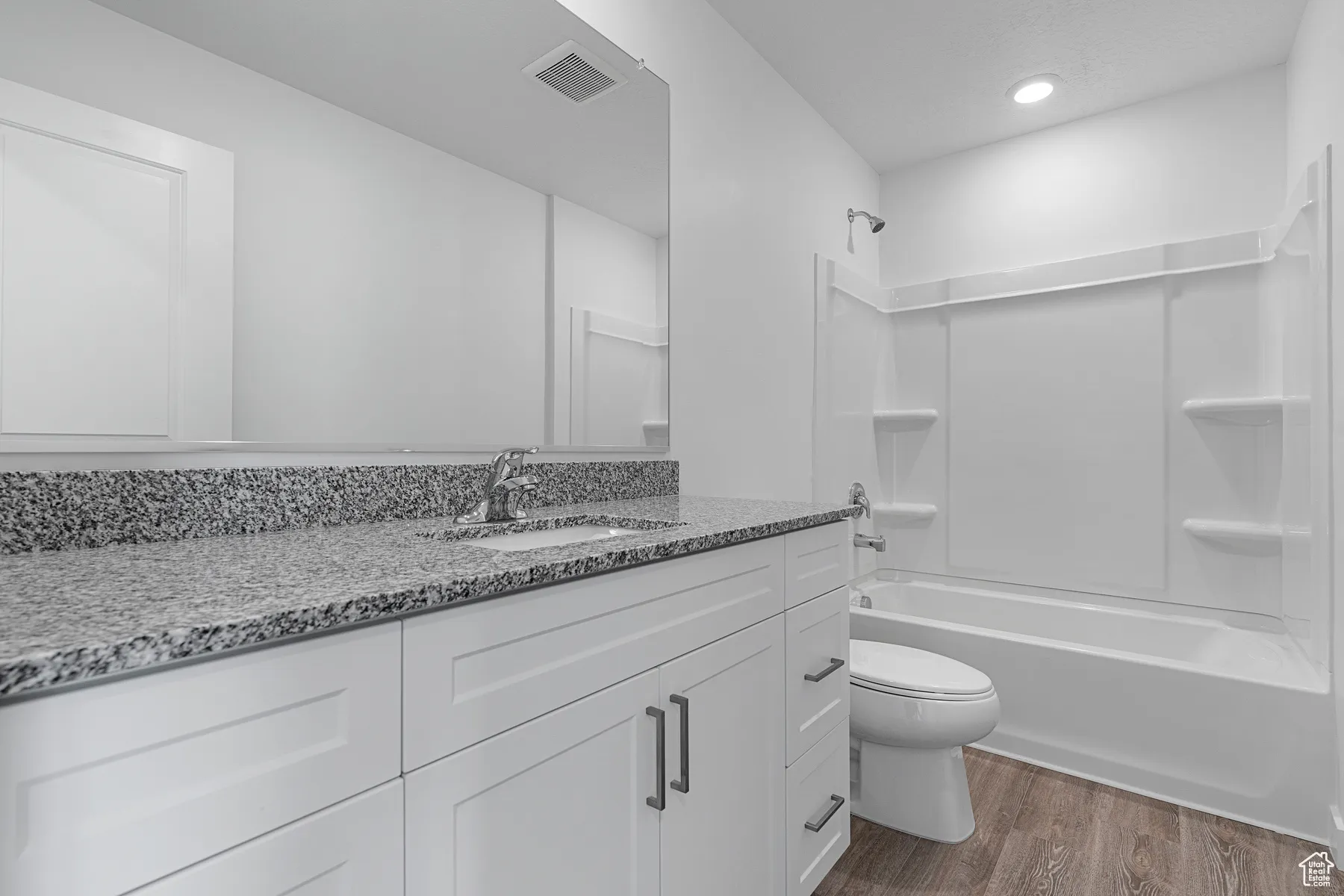 Bathroom with shower / washtub combination, vanity, and dark wood-style floors