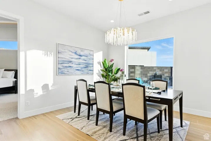 Dining room featuring light wood-style floors, a chandelier, and recessed lighting